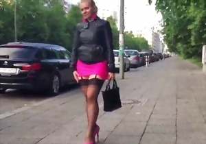 Sweetheart in a pink miniskirt looks good on glossy high heels
